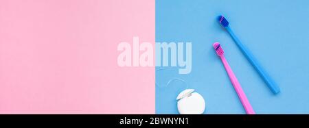 Teeth hygiene and oral dental care products on color pink and blue background with copy space. Blank dental floss and brushes. Flat lay, top view comp Stock Photo