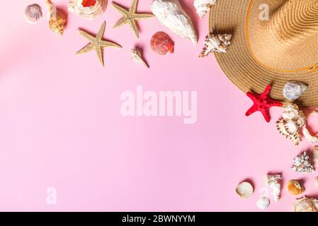 Vacation travel equipment Straw hat, and marine objects, shells, starfish On a pink background Stock Photo