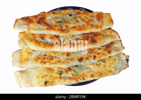 Freshly baked homemade tortillas with green onions and asparagus on a plate close-up. Stock Photo