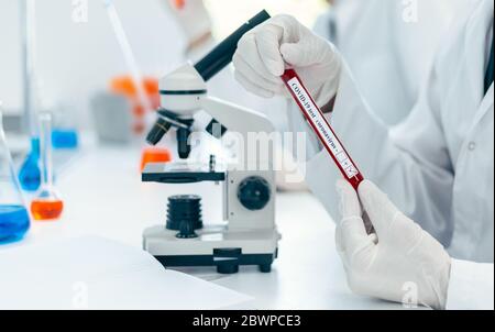 close up. scientist reading the inscription on the tube with the test. Stock Photo