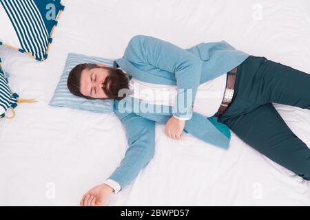 Recovery and recharging. Feel tired and sleepy. Sleepy guy in formal clothes sleep bed top view. Lack of sleep. Need more sleep. Evening time. Businessman exhausted. Sleeping in fashionable clothes. Stock Photo