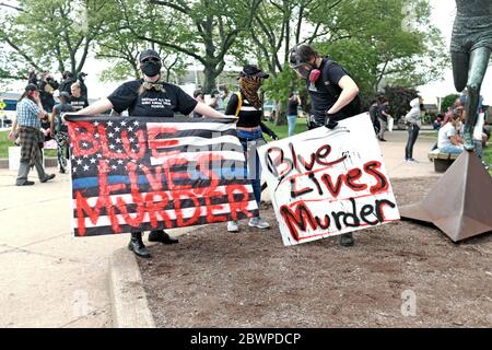 Protesters in Cleveland, Ohio, USA hold signs stating Blue Lives Murder during protests against the murder of George Floyd in the hands of police.
