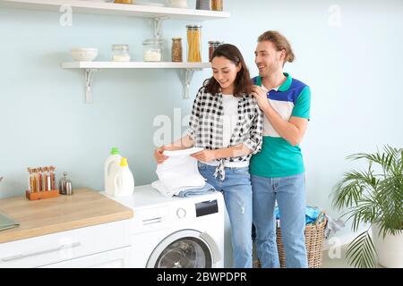 Happy young couple doing laundry at home Stock Photo