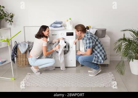 Happy young couple doing laundry at home Stock Photo