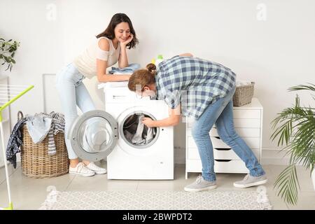 Happy young couple doing laundry at home Stock Photo