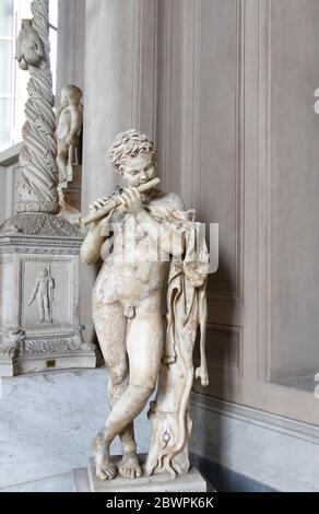 Vatican City, Vatican - May 20, 2019: Ancient Roman statue of a young boy on flute in Vatican Museums Stock Photo