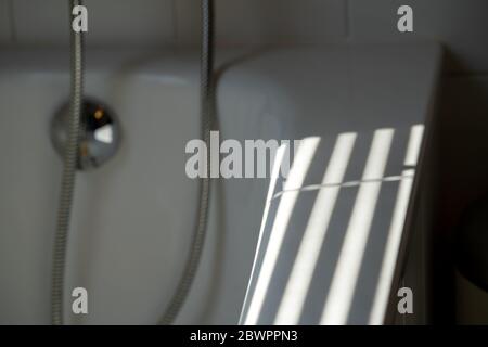 Industrial design window sunlight parallel lines shadows. Light and shadow from the window. Thin lines of light on the wall. Shadow from the blinds. Stock Photo