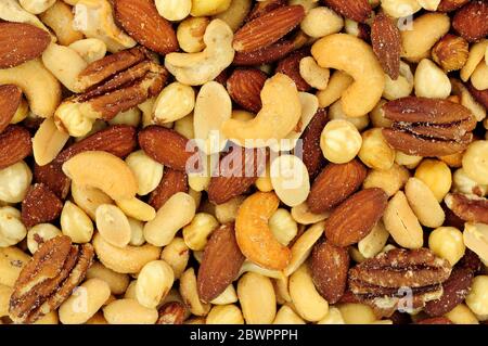 Roasted salted mixed nuts flavourful snacking background Stock Photo