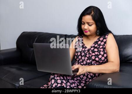 An Indian woman works on a laptop at home Stock Photo
