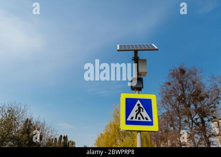 The pedestrian crossing sign powered by solar panels installed above. Traffic signs and rules. Stock Photo