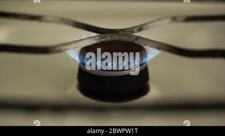 lit burner on a gas stove close-up, communal price reduction. Stock Photo