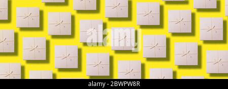 Valentine's Day. Grey gift box pattern on yellow background. Top view. Copy space. Creative design for packaging. Festive backdrop for holidays: Birth Stock Photo