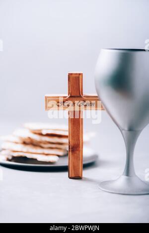 Matzos unleavened bread, chalice of wine, wooden cross on grey ...