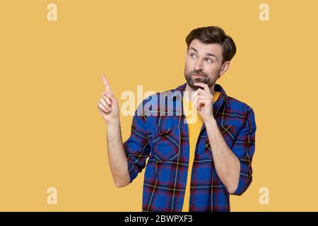 Young bearded man looking thoughtfully up and to the side Stock Photo