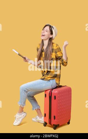 Joyful girl in hat and sneakers dreamily closing her eyes. Stock Photo