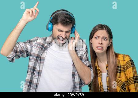 Inspired man in headphones and displeased girl Stock Photo