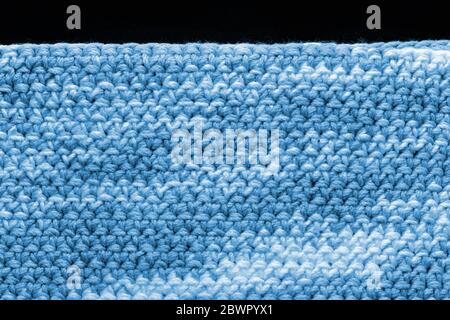 Crocheted fragment of melange yarn close-up. Handmade concept. Abstract background blue color toned Stock Photo