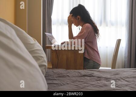 Concentrated woman solves a difficult task while working on a laptop from home.  Photo with soft focus Stock Photo