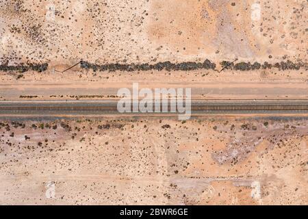 Aerial top down views of the railway line on the dry pink lake on the Coolgardie-Esperance highyway just north of Norseman in Western Australia Stock Photo