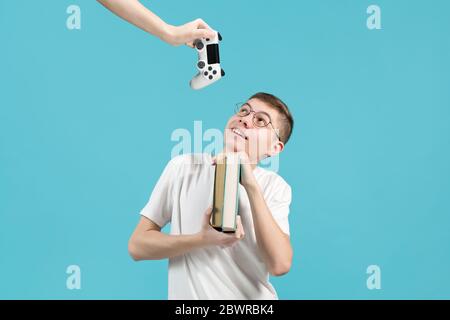 nerd holding books in his hands and smiling looking up Stock Photo