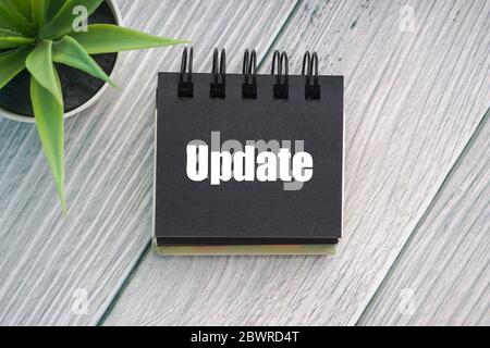 UPDATE text with decorative plant and notepad on wooden background. Business concept Stock Photo