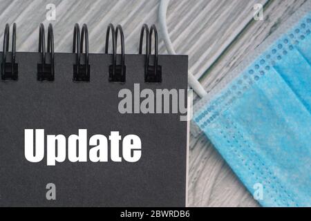 UPDATE text with protection facemask on wooden background. Healthy and Coronavirus concept Stock Photo