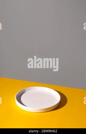 White empty plate on a yellow background. Stock Photo