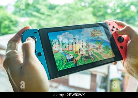 Bangkok, Thailand - May 26, 2020 : A man playing Animal Crossing on Nintendo Switch. Stock Photo