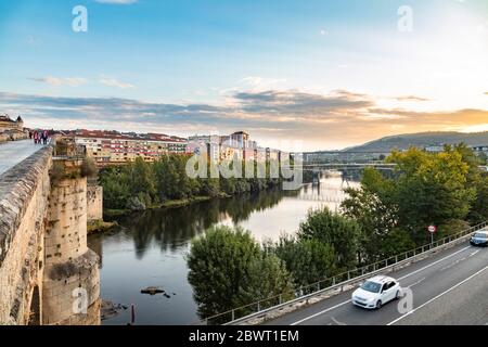 People crossing the Roman bridge early in the morning, Ourense, Galicia, Spain.