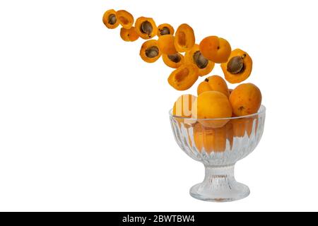 flying fruit apricots isolated on a white background. juicy fruit falls into a glass bowl. selective focus. Stock Photo
