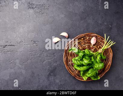Fresh garden herbs. Top view of green basil on black background. Stock Photo