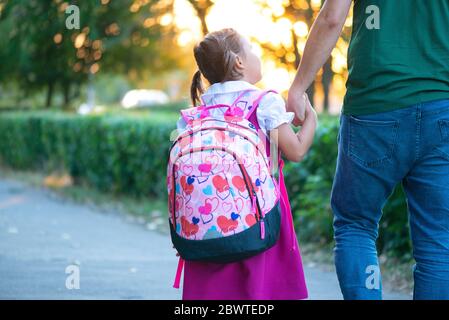 first day at school. father leads a little child school girl in first grade Stock Photo