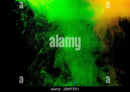 Abstract colored dust explosion on a black background.abstract powder splatted background, Freeze motion of color powder exploding/throwing color powd Stock Photo