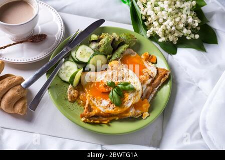 Healthy brunch poached eggs on a bed of smashed avocado with coffee. Stock Photo