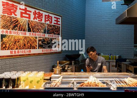 Chongqing, China -  August 2019 :  Meat, snacks, kabap vendor selling food on the street in the Ci Qi Kou Old town Stock Photo
