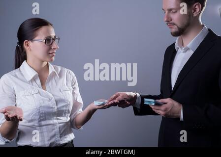 Portrait of two young businessmen in business clothes. A business woman in glasses, emotionally gesturing with her hands, is indignant at a small sala Stock Photo