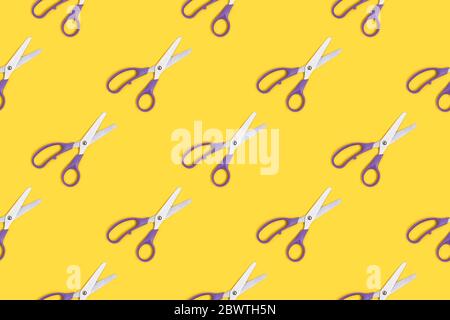 Scissors pattern on a yellow background. Office supplies layout. Stock Photo