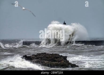 A change in the weather as the mini heatwave comes to an end with rough seas off the north east coast at Seaham in County Durham. Stock Photo