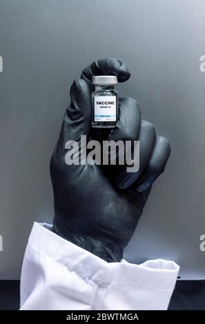 Cropped image of scientist's hand holding COVID-19 vaccine sample at laboratory Stock Photo
