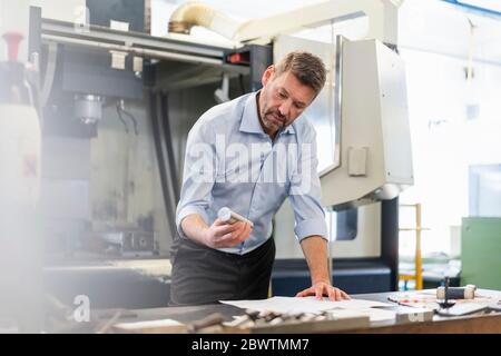 Man examining workpiece in a factory Stock Photo