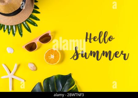 Summer background. Palm leafs with starfish and seashell on yellow background with text "Hello Summer". Summer, Travel or Vacation. Stock Photo