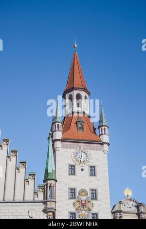 Germany, Bavaria, Munich, Low angle view of Old Town Hall clock tower standing against clear blue sky Stock Photo