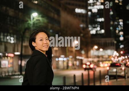Portrait of a confident young woman in the city at night, Frankfurt, Germany Stock Photo