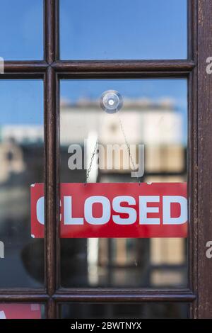 closed sign hanging behind glass in store front door Stock Photo - Alamy