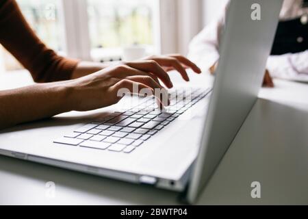 Cropped image of businesswoman working on laptop at desk in office Stock Photo