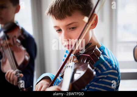 Boy playing violin during a lesson Stock Photo