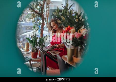 Woman reading magazines in a shop Stock Photo - Alamy