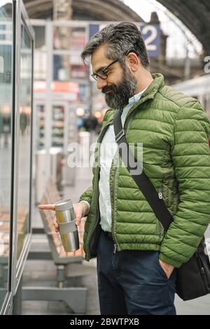 Man checking the timetable at the train station Stock Photo