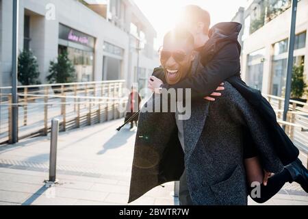 Carefree young couple in the city at sunset Stock Photo