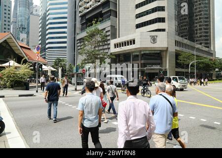 People crossing a street in the central business district of Singapore. Stock Photo